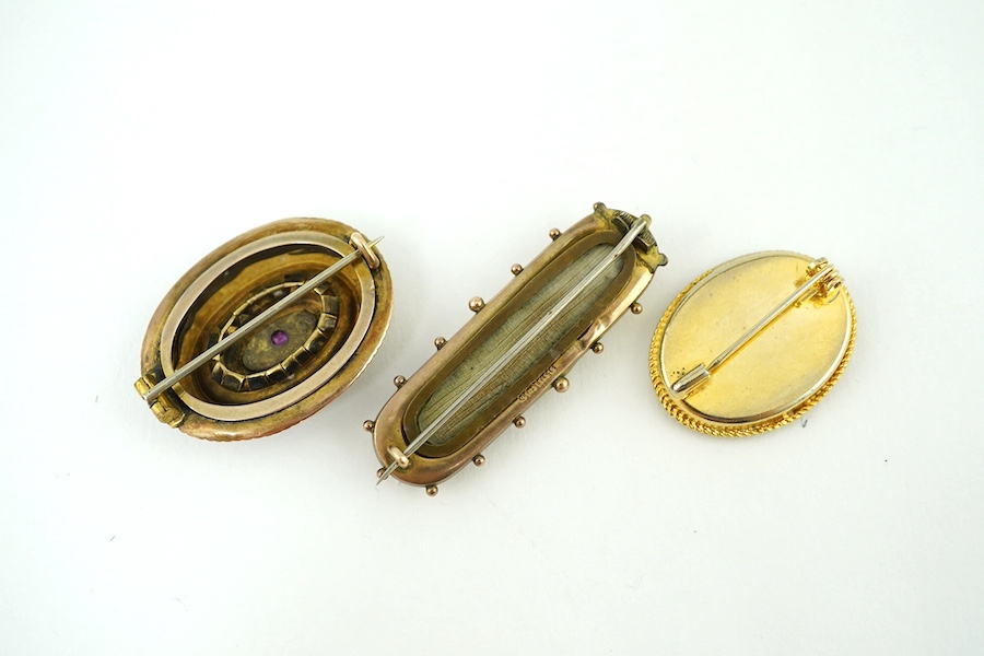 Two late Victorian yellow metal, ruby and seed pearl set brooches, largest 46mm, gross weight 10.9 grams and one other costume brooch. Condition - poor to fair